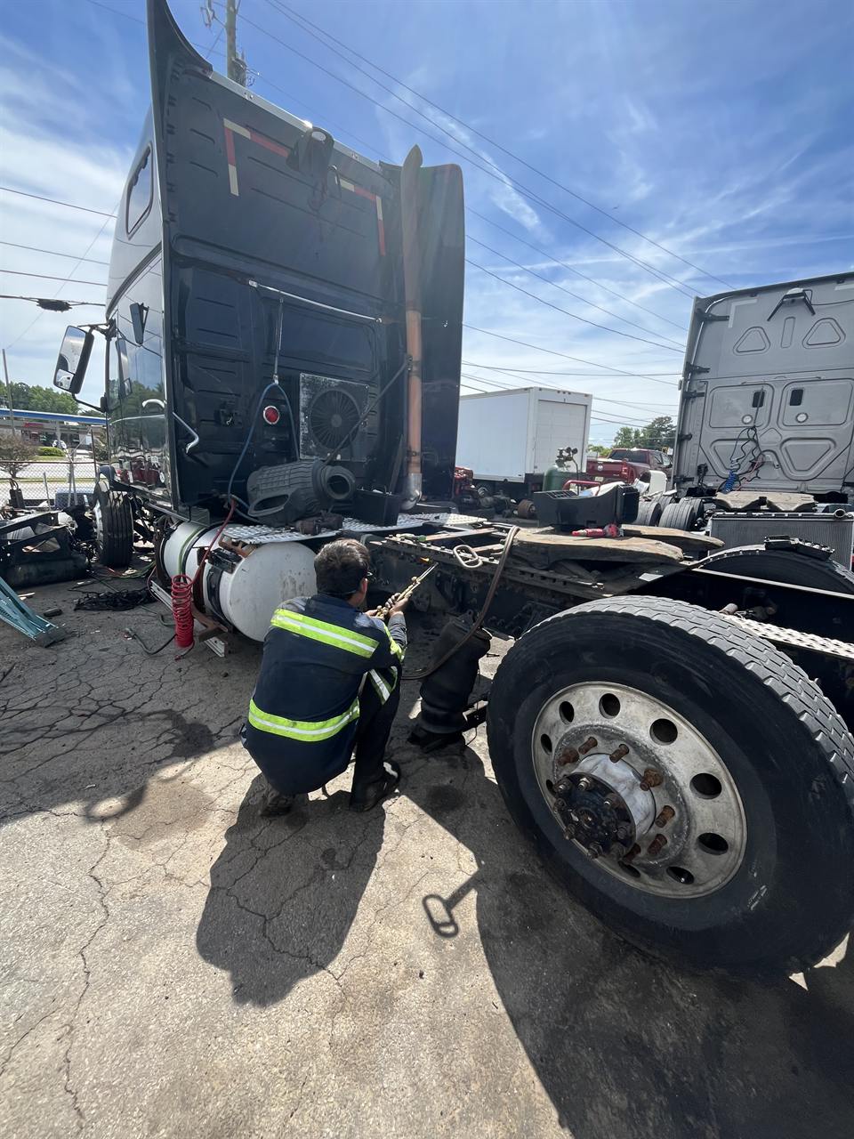 Technician working on a semi truck driveline on-site